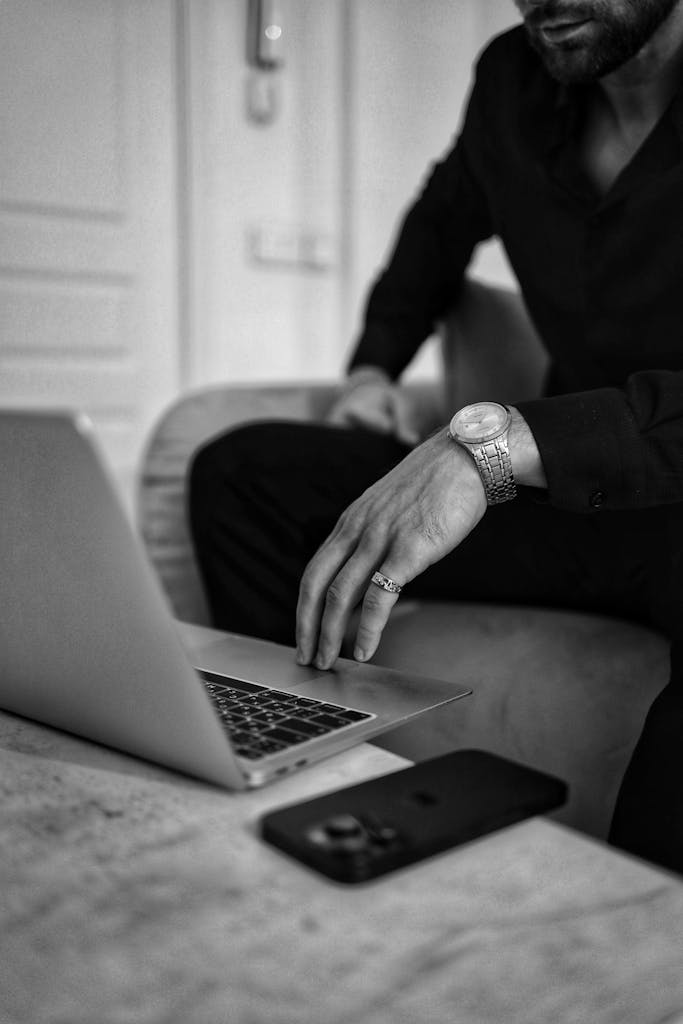 Black and White Photo of a Man Using Laptop